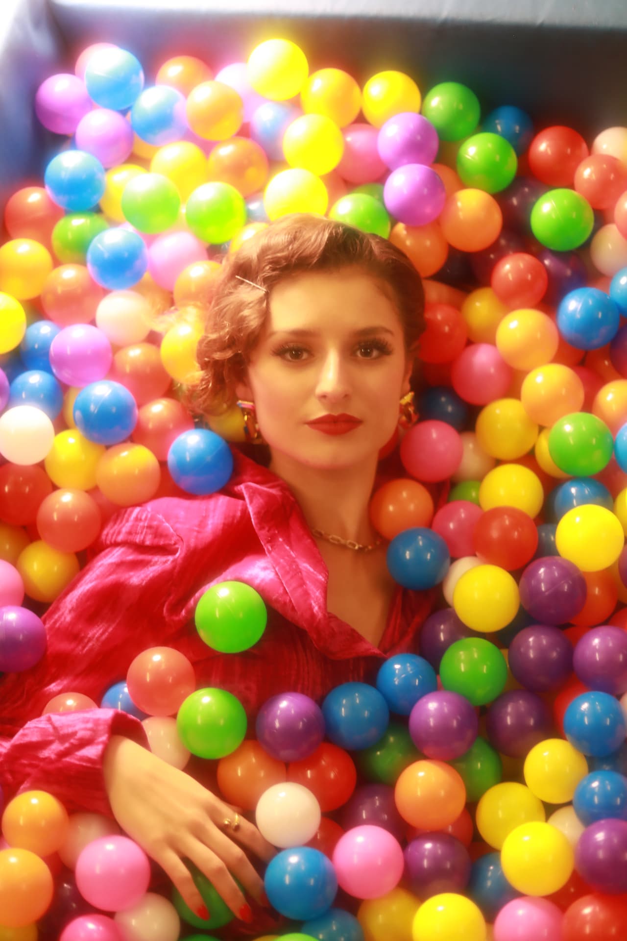 Shannon Kitchen in a pink jacket among colourful balls